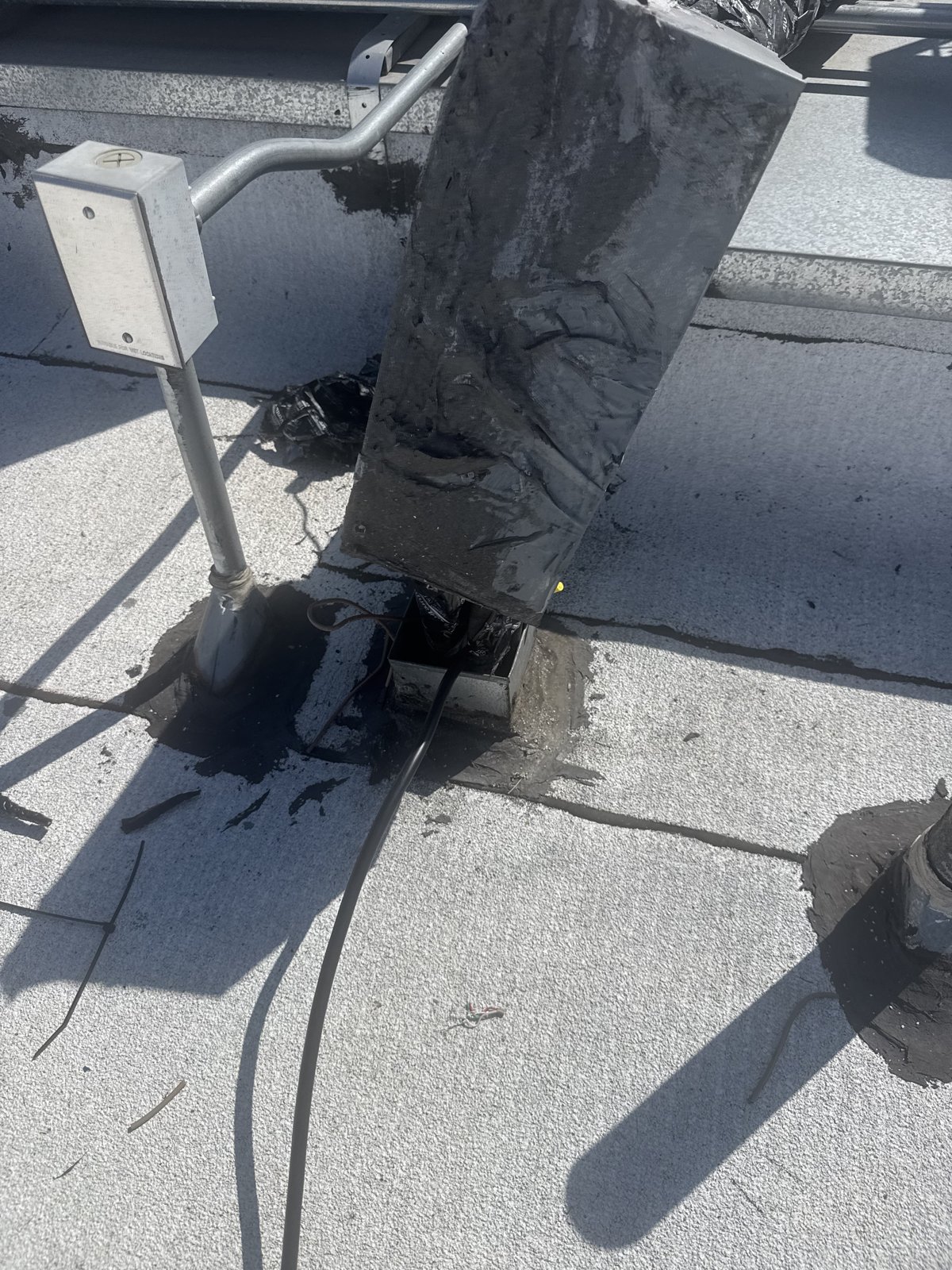 AC line set and conduit coming up through a sealed apartment building roof.